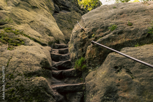 Fotografía Eine in den Felsen geschlagene Steintreppe führt durch eine enge Schlucht zwischen massiven Sandsteinwänden