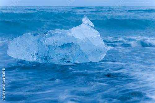 Ice floes lying on a black beach near Jokulsarlon glacier lagoon in Iceland