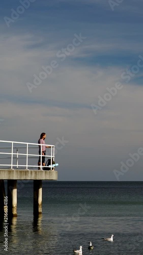 Sea view with male backpacker on pier.  Vertical video