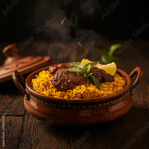 Delicious Mutton Biryani Served in Traditional Brass Bowl with Herbs and Spices
