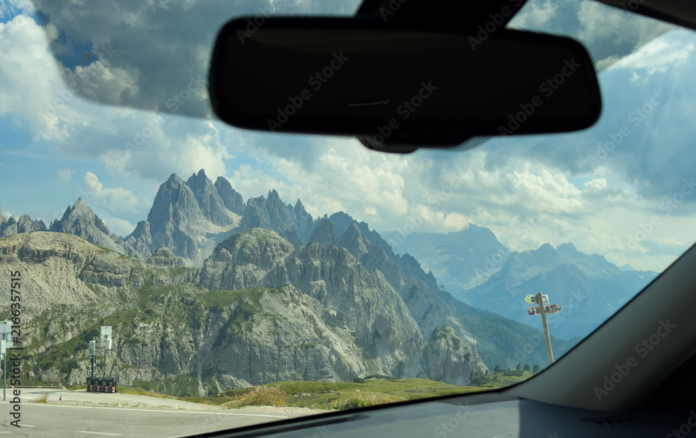 Fototapeta premium Mountains mirror on a road at sunset, concept of travel, journey, and looking back at the past. 