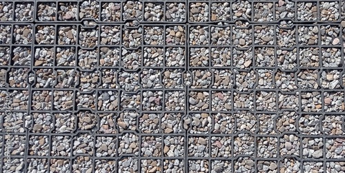 Outdoor surfacing made of rubber mesh and small stones.