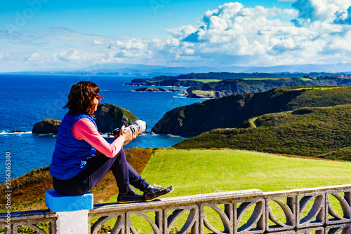 Tourist with camera on Asturias coast, Spain