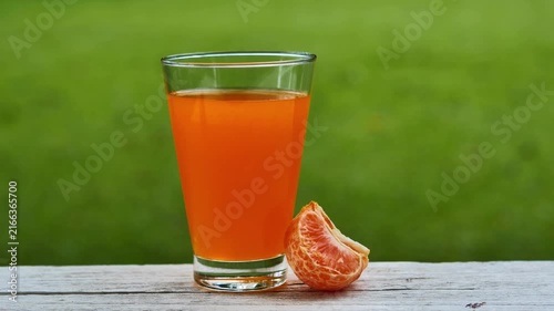 Fresh orange juice in a glass under natural sunlight