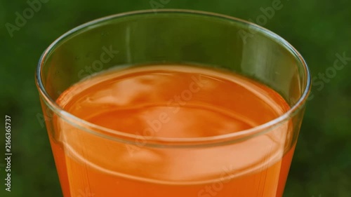 Fresh orange juice in a glass under natural sunlight