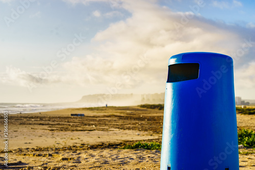 Empty beach with trash can