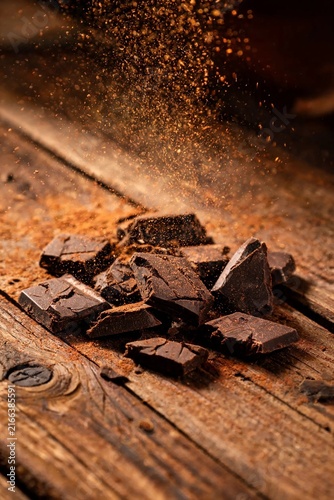 Cocoa Powder Dusting Over Chocolate Pieces On Rustic Wooden Boards Dramatic Motion Sweet Dessert