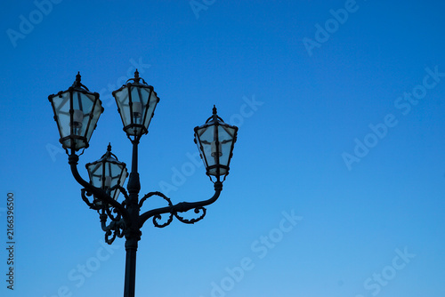 Canvastavla Decorative historic street lamp silhouetted against a clear blue sky in Vienna, Austria, with generous copy space for travel, tourism and European heritage designs
