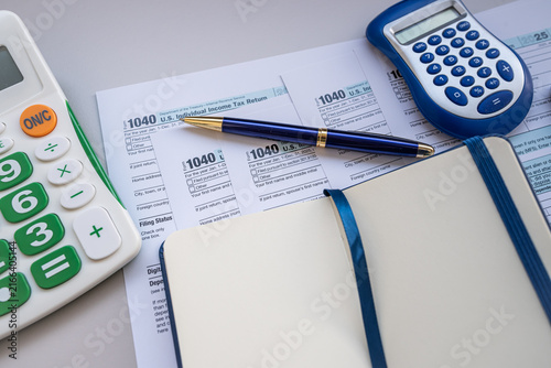 Tax Return Form 1040 Papers with Calculator Notebook and Pen for Personal Financial Planning