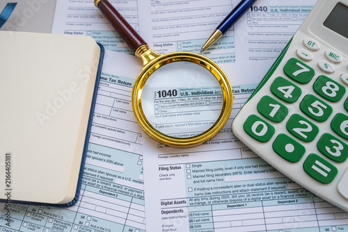 Tax Preparation Workspace with Form 1040 Magnifying Glass Calculators and Pen on Office Desk