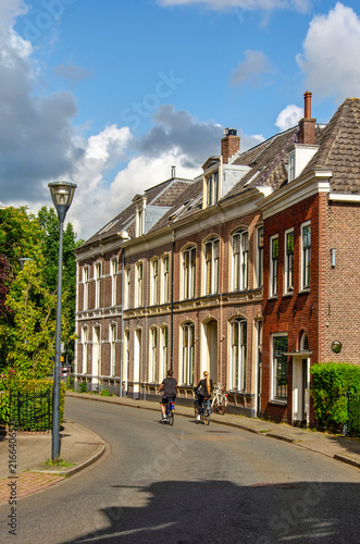 Zwolle, The Netherlands, July 27, 2026: two bicyclists in a street in the old town lined with brick facades