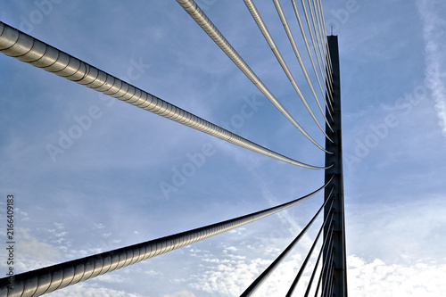 heavy steel suspension bridge draw cables in diminishing perspective view looking up. abstract closeup detail. blue sky background. famous bridge in Valencia, Spain. architecture, travel and tourism