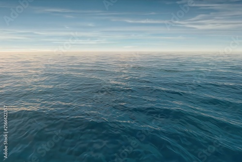 Wide view of a tranquil open ocean stretching to the horizon with low rolling waves and subtle surface texture. The scene features a pale blue sky with thin