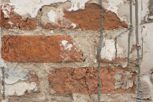 Foto Old red brick wall texture, damaged plaster on brickwork with concrete cement drips, grunge weathered architectural background