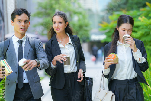 Photography A diverse team of three business professionals sharing lunch on the go between m