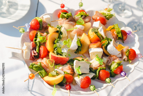 Canapés on skewers. A plate with canapés for a buffet.