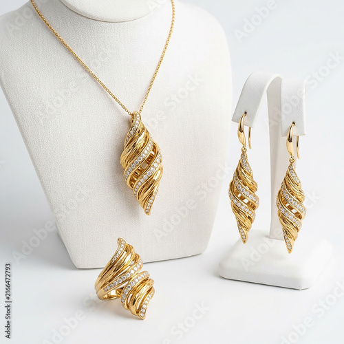 Luxury gold jewelry set with spiral design pendant, earrings, and ring on white display stand