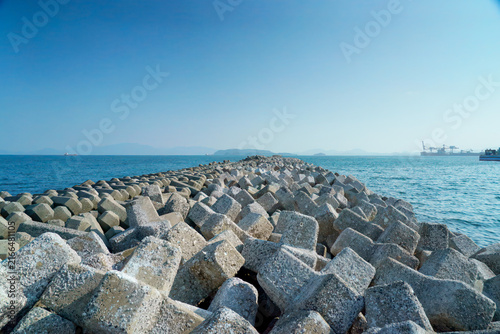 Concrete Breakwater Along Calm Sea Coastline