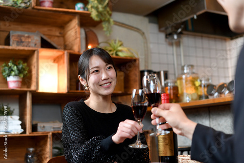 飲食店でワインで乾杯する笑顔のアジア女性