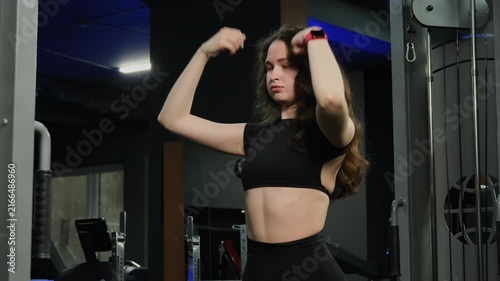 Motivated woman athlete performs slow arm warm-up exercises. Female bends and straightens arms to improve blood circulation before training