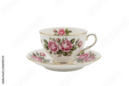 A classic white porcelain teacup and saucer set decorated with a delicate pink rose floral pattern and gold rim details on a black background