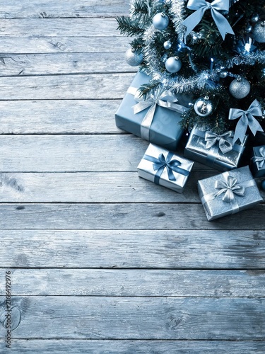 Wrapped Gifts Under Decorated Christmas Tree On Rustic Wooden Boards
