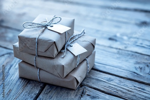 Stack of Kraft Paper Gifts with Twine on Rustic Wooden Boards
