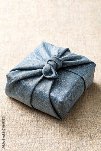 Gift Wrapped Fabric Furoshiki Style on Natural Linen Texture