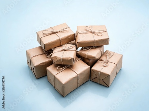 Stack of Kraft Paper Gifts with Twine on Pastel Studio Background