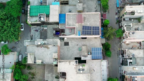 Aerial view of residential rooftops and solar panels in New Delhi, India.