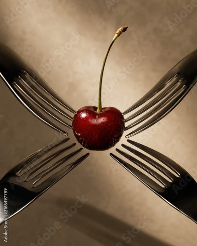 Surreal conceptual still life photo of a single glossy fresh red cherry held in suspension by four metal forks pointing inward on moody textured neutral background