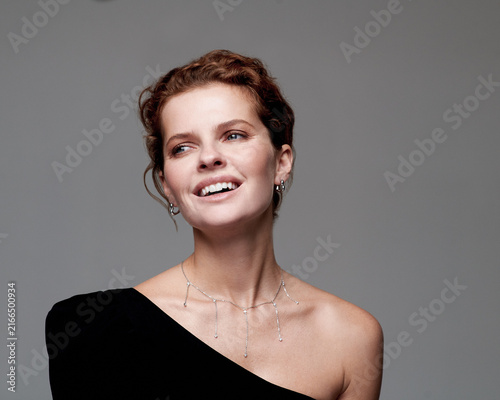 Cuadro en lienzo Elegant Model Showcasing Jewelry with a Bright Smile Against a Minimalist Backgr