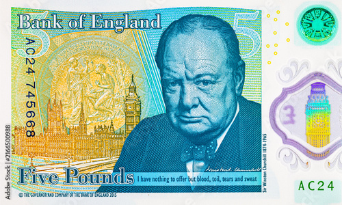 British five pound polymer banknote featuring the portrait of Sir Winston Churchill, the Houses of Parliament, Elizabeth Tower and Nobel Prize medal details. United Kingdom national currency.
