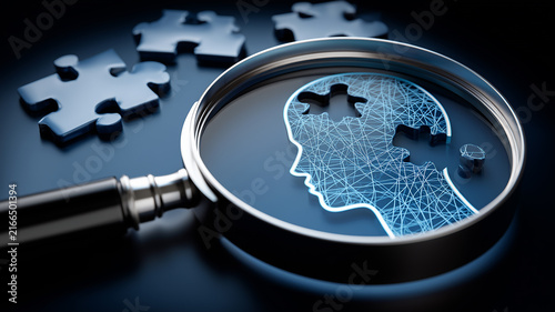 Obraz w ramie A magnifying glass focused on a human profile with puzzle pieces representing psychology, cognition and problem solving. 