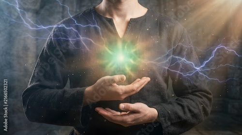 Person Performing Lightning and Energy Control with Hands in Dark Atmosphere