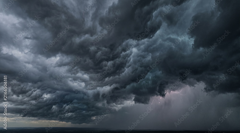 Obraz premium Dark ominous storm clouds with lightning strike in the distance