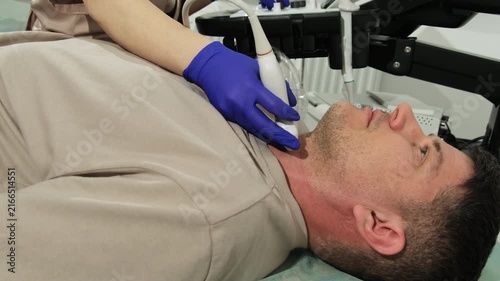 Doctor gloved fingers guide probe on man neck with gentle pressure. Patient serene expression suggests reassurance and professionalism