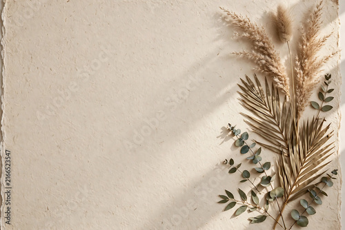Pressed dried botanical flatlay on textured handmade paper with soft sunlight shadows.