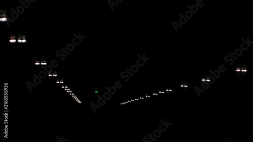 POV inside airplane cabin with safety light up along the overhead panel and light off while prepare cabin ready to land approaching to airport destination,dark aircraft cabin while landing to airport