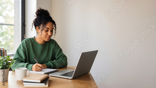 Young student studying at a desk with laptop