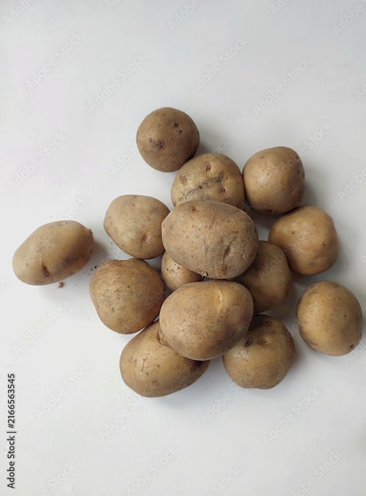 Fototapeta premium Fresh raw potatoes arranged on a clean white background, showcasing natural organic vegetables, healthy food ingredients, and rustic farm produce.