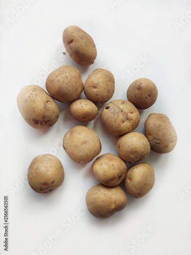 Fresh raw potatoes arranged on a clean white background, showcasing natural organic vegetables, healthy food ingredients, and rustic farm produce.