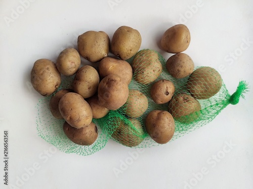 Fresh raw potatoes arranged on a clean white background, showcasing natural organic vegetables, healthy food ingredients, and rustic farm produce.