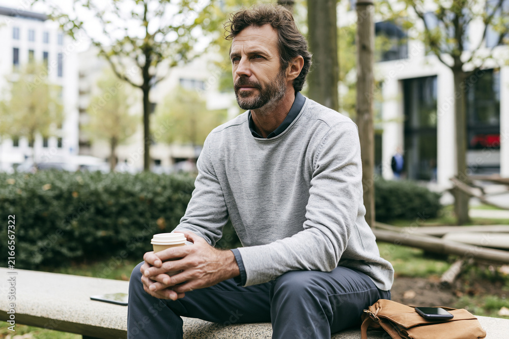 Fototapeta premium young man sitting on bench