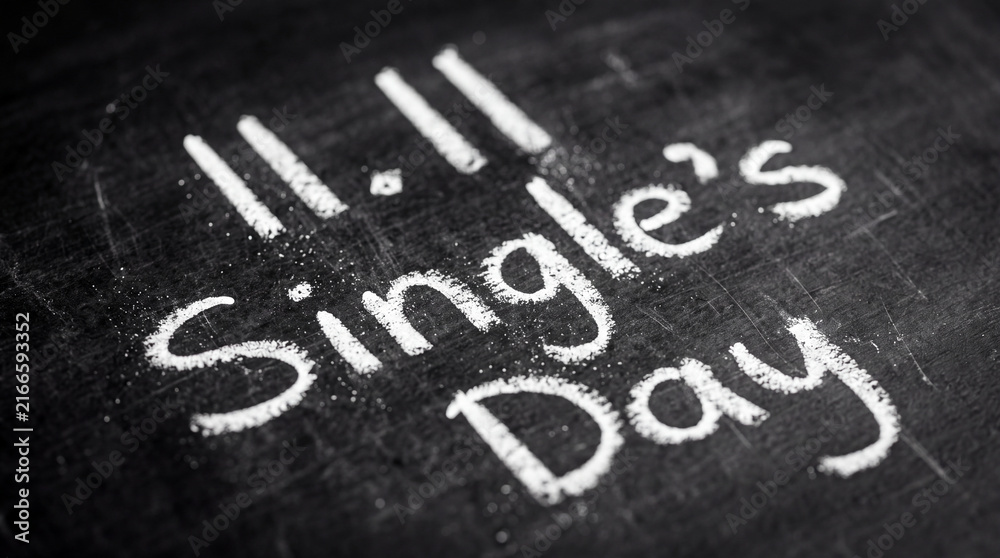 Fototapeta premium The text 11.11 Single's Day is written in white chalk on a black chalkboard surface, symbolizing the global online shopping festival and e-commerce holiday.