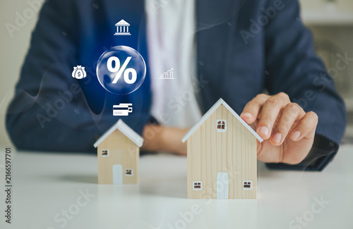Foto Mortgage financing concept with businessperson holding model house to represent interest rates home loans banking property investment affordability financial planning and real estate
