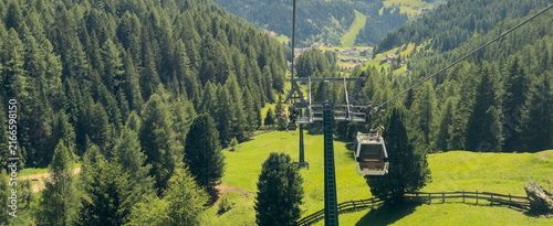 Aerial view from cable car gondola over Alpine valley and pine forest, Seceda, Val Gardena, Dolomites, Italy Stock Photo
