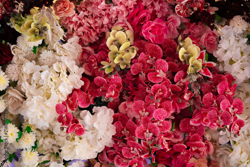 Foto Colorful Artificial Flower Wall Background with Roses and Orchids
