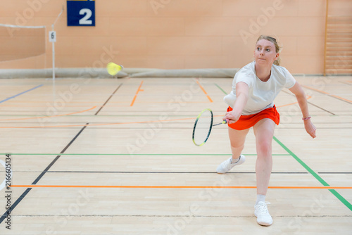 Woman compete in badminton tournament on indoor court