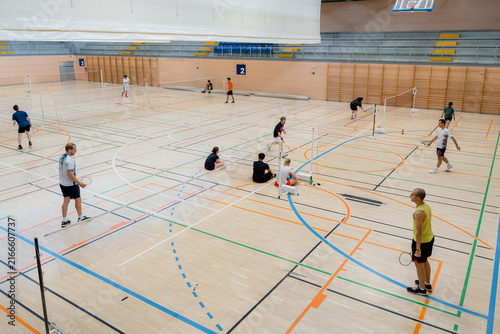 Badminton tournament players compete in indoor sports hall